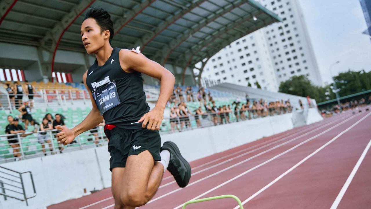 Nam vận động viên tăng tốc chạy nước rút trên sân vận động trong giải Ekiden do Active Fox tổ chức tại TP.HCM