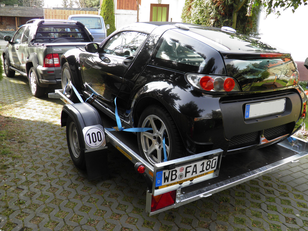 schwarzer Coupe auf Trailer angekommen
