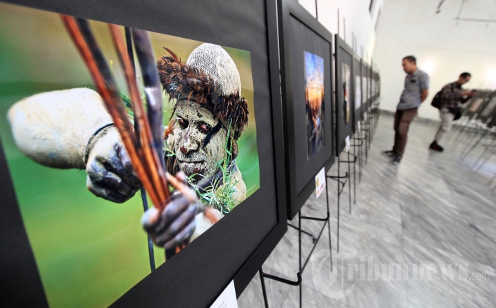 Pengunjung mengamati karya foto pada pameran bertema 