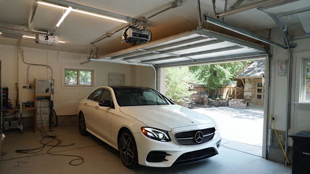 Belt-drive smart garage door opener system installed on garage ceiling