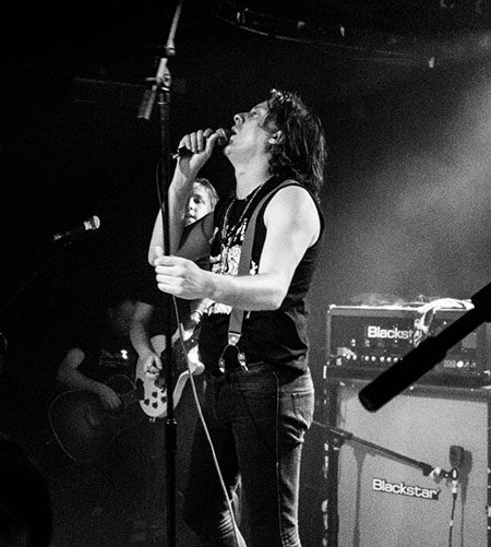 Carl Barat at Camden Rocks - cropped almost square with audience and cameras removed, black and white with adjustment to contrast, clarity and shadows/highlights