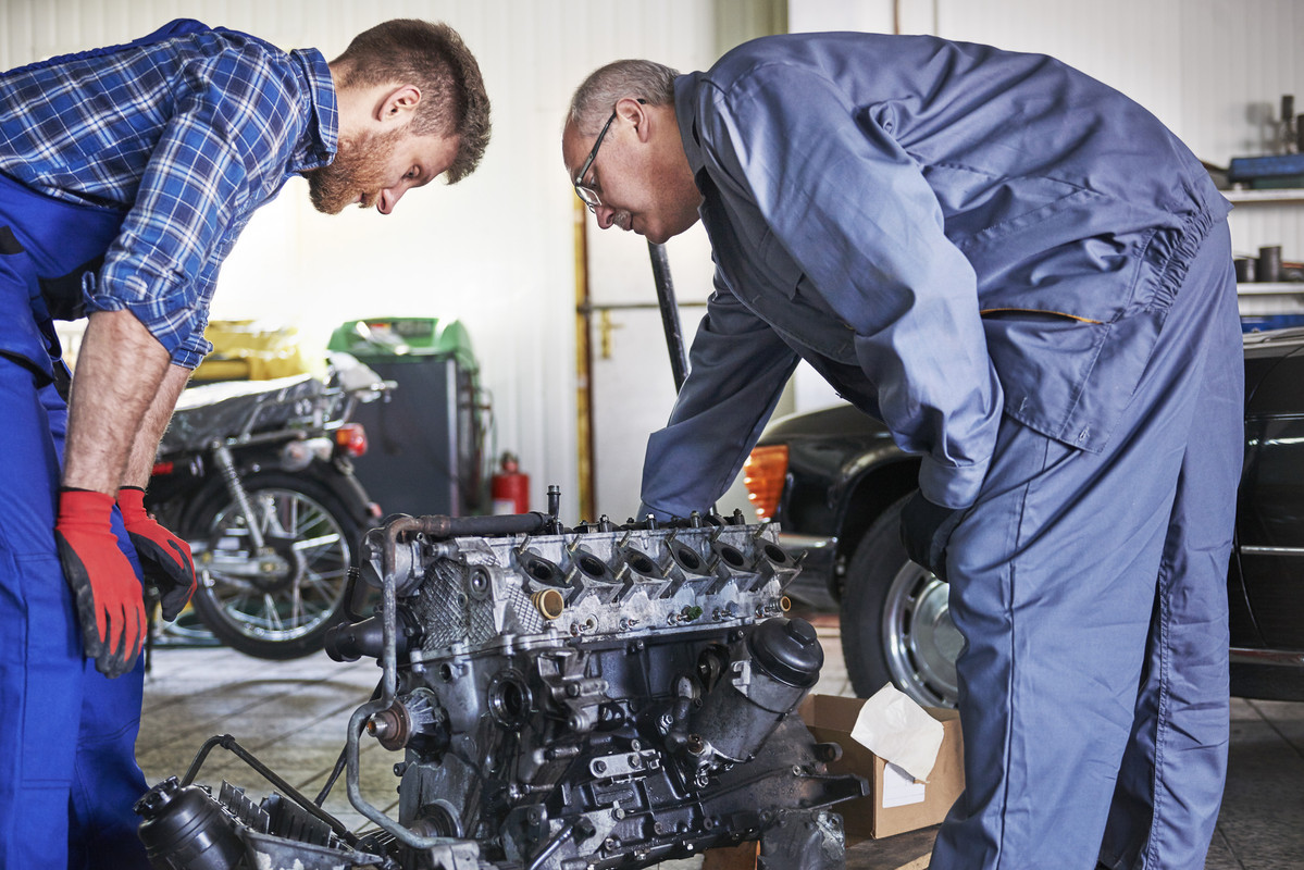 mechanics-repairing-car-workshop (1)