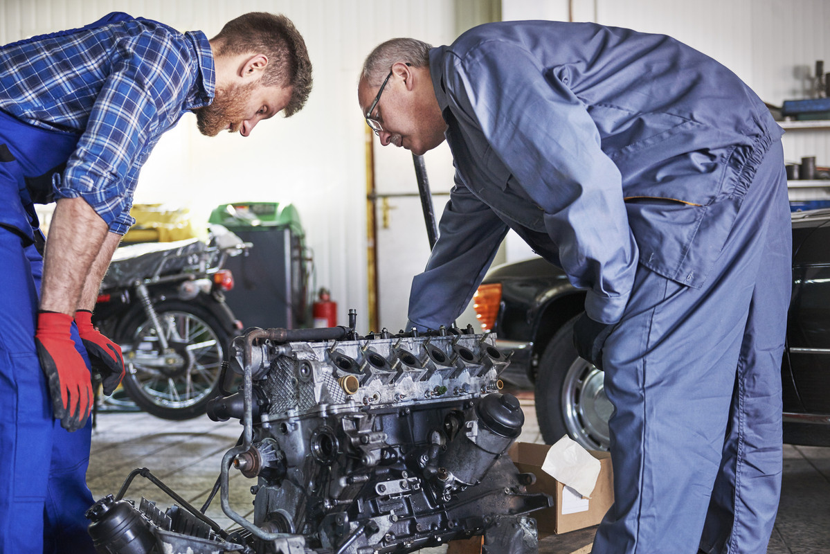 mechanics-repairing-car-workshop-1.jpg