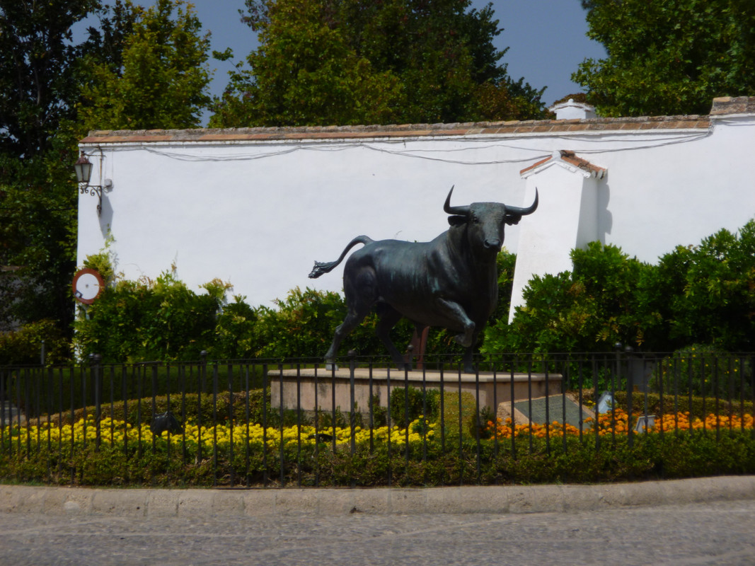 Statue of a bull, it's tail flicking, head up and right front leg raised as if in mid-turn.