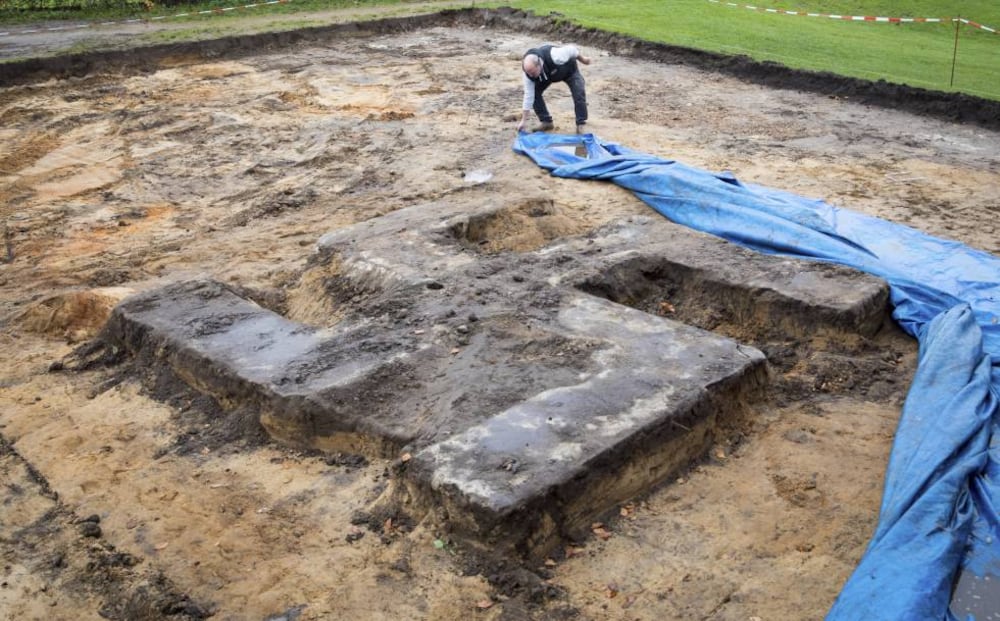 Un hombre retira una lona que cubre la esvástica nazi