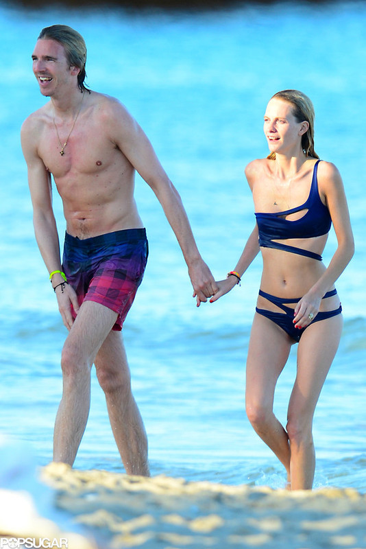 Med henne smal kropp och Mörk brun hårtyp utan behå (kupstorlek 32B) på stranden i bikini
