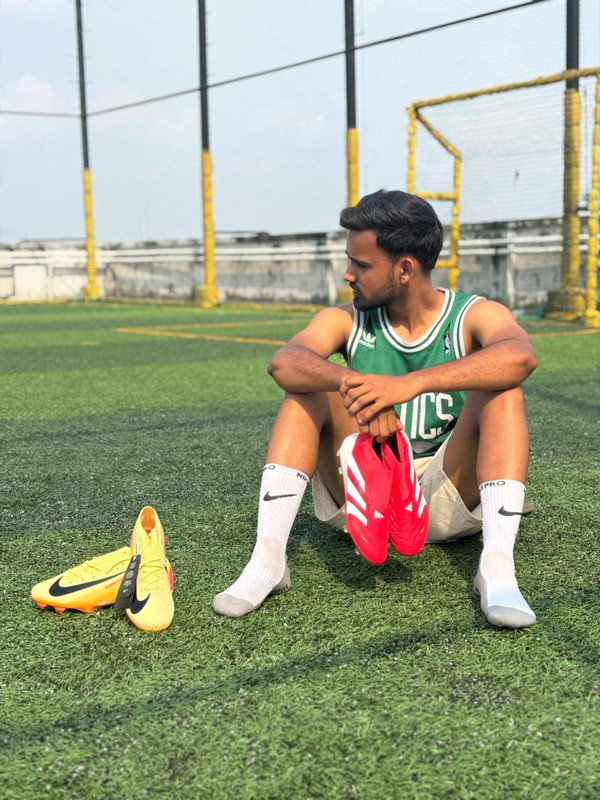 Close up on a player's feet wearing modern football cleats on grass.