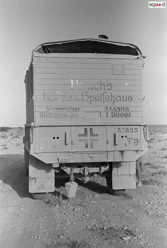 Trois soldats regardent l'arrière d'un camion appartenant au train de ravitaillement du Pz.Art.Rgt-1