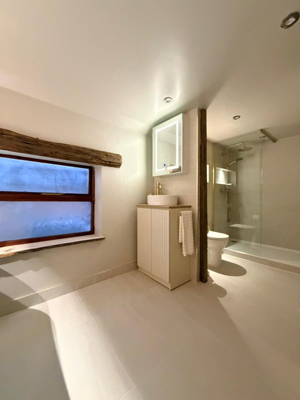 Rustic bathroom with vanity, window, and shower space