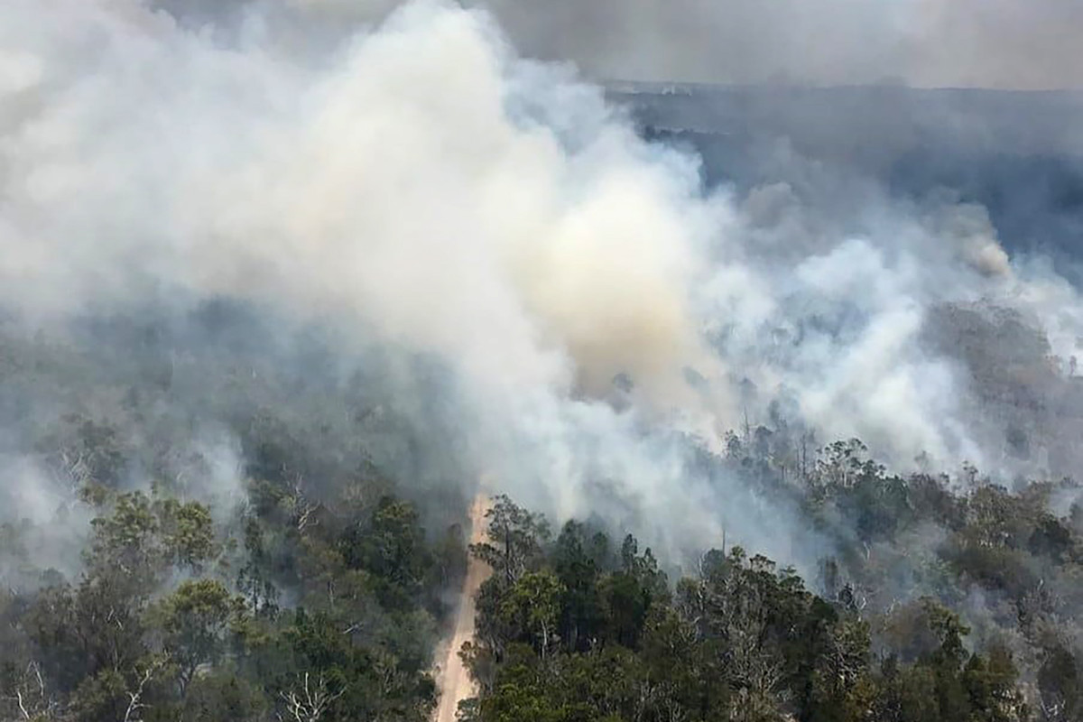 Gambar selebaran ini diambil pada tanggal 29 November 2020 dan dirilis oleh Layanan Kebakaran dan Darurat Queensland menunjukkan pemandangan udara dari kebakaran hutan di Pulau Fraser, lepas pantai timur Australia.