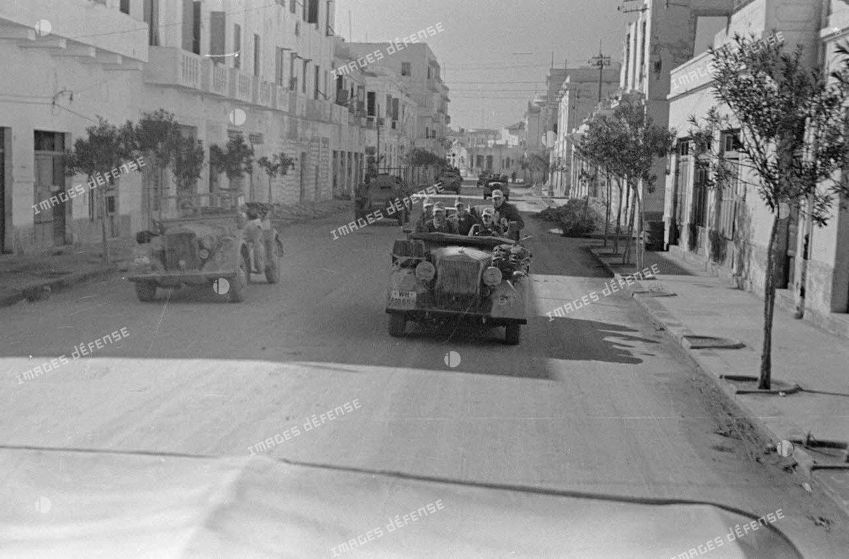 Des véhicules de la 21e division blindée allemande (21-Panzer-Division) roulent dans les rues de la 