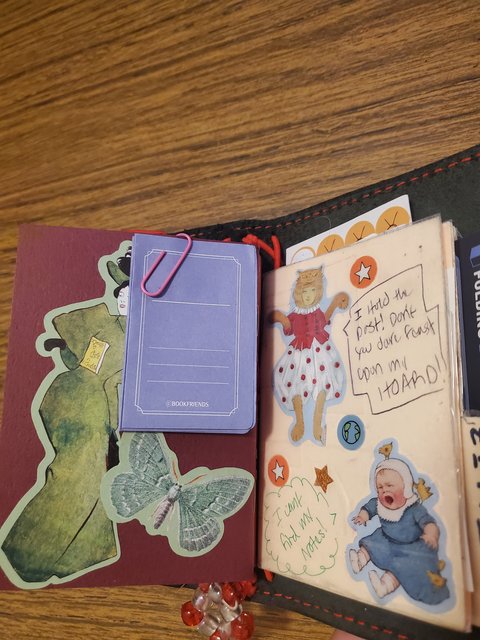 The back of the Stalis, has post-it notes that look like books when folded up, the front cover of my folder features a crying baby and an antique/retro furry suit wearing girl.