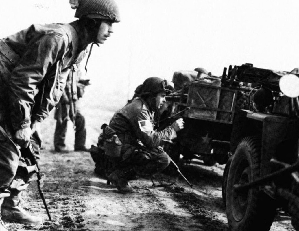 Un paracaidista británico de la 6ª División Aerotransportada, combatiendo junto a elementos de la 17 División Aerotransportada de los EE.UU. Obsérvese el arma que porta el aerotransportado estadounidense. Bien podría ser una pistola Luger