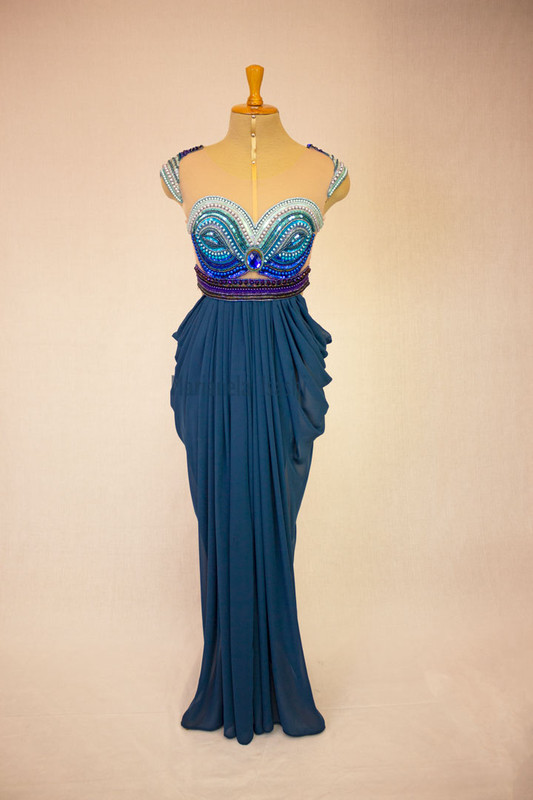 Long evening dress in turquoise with sweetheart neckline, bare shoulders and embroidery details in rhinestones.