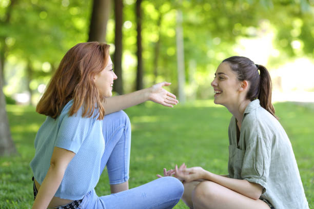 two-friends-talking-sitting-in-a-park.jpg