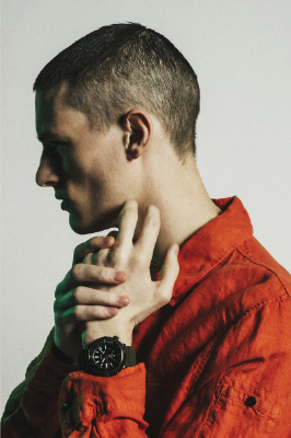 Young male in red shirt showing his new watch.