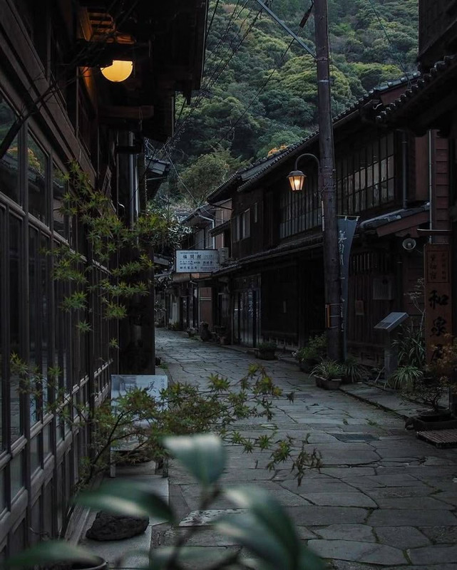 Photographie d'une ruelle d'un petit village japonais traditionnel lors des dernières lueurs du soleil