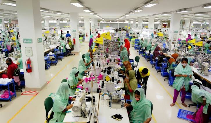Garment worker operating a Brother sewing machine on the production floor