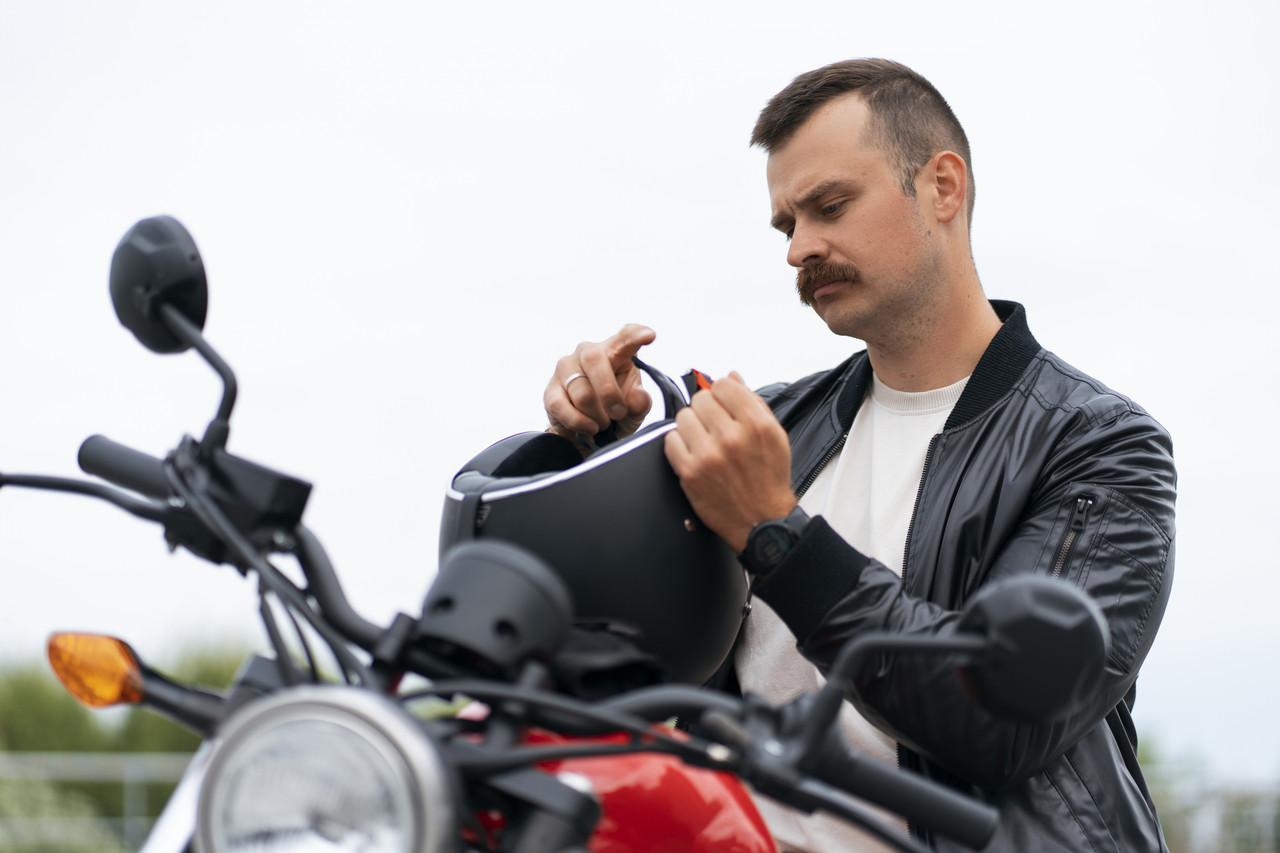 medium shot man with motorbike outdoors