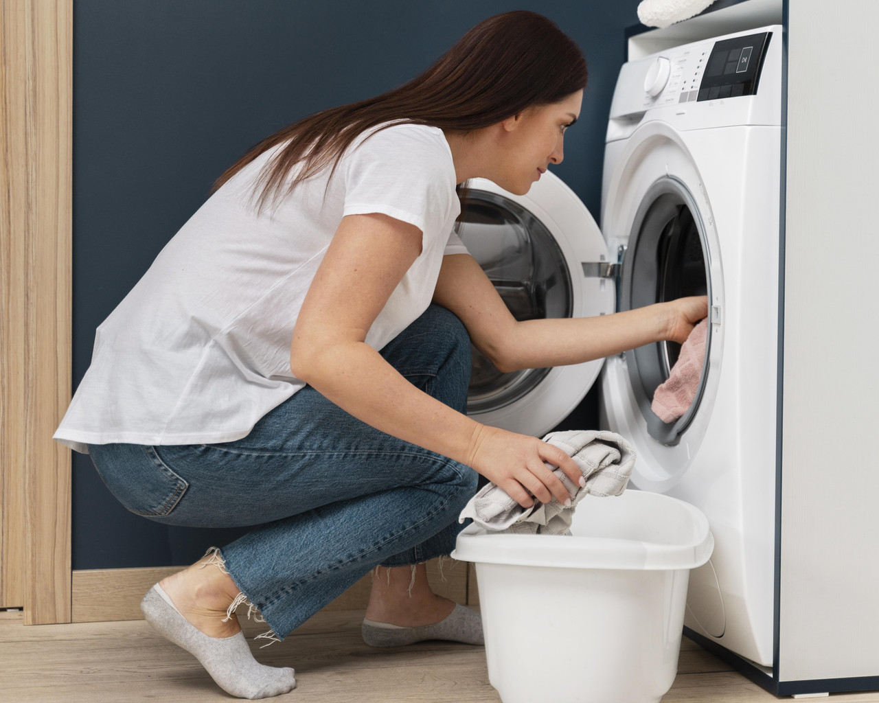 woman putting dirty clothes washing machine