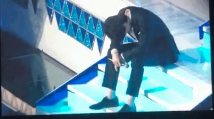 Lee Dong Wook terlihat duduk sambil menunduk setelah membacakan peserta yang lolos 11 besar Produce X 101