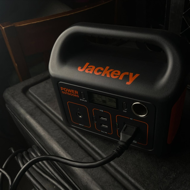 Lifestyle product photography of a Jackery portable power station plugged in and charging