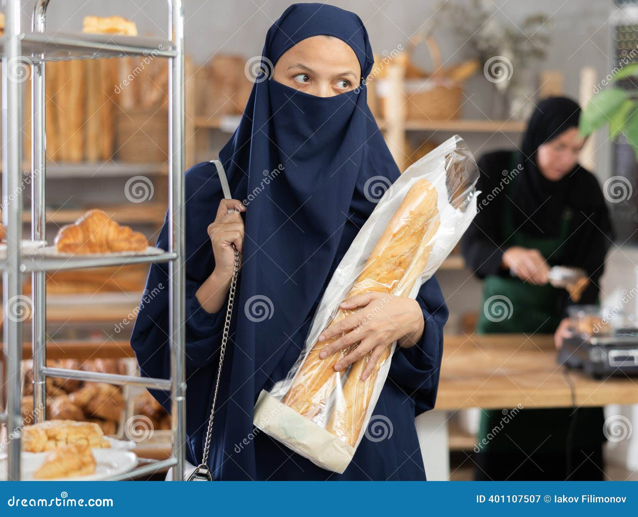 C:\Users\lenovo\Pictures\Saved Pictures\muslim woman\donna-musulmana-niqab-con-baguette-fare-shopping-mani-al-forno-una-calma-e-concentrata-nel-blu-tiene-mano-confezionate-mentre-401107507.jpg