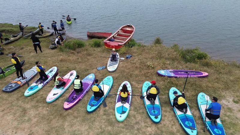 Grupo preparando las tablas de SUP a orillas del río Rapel