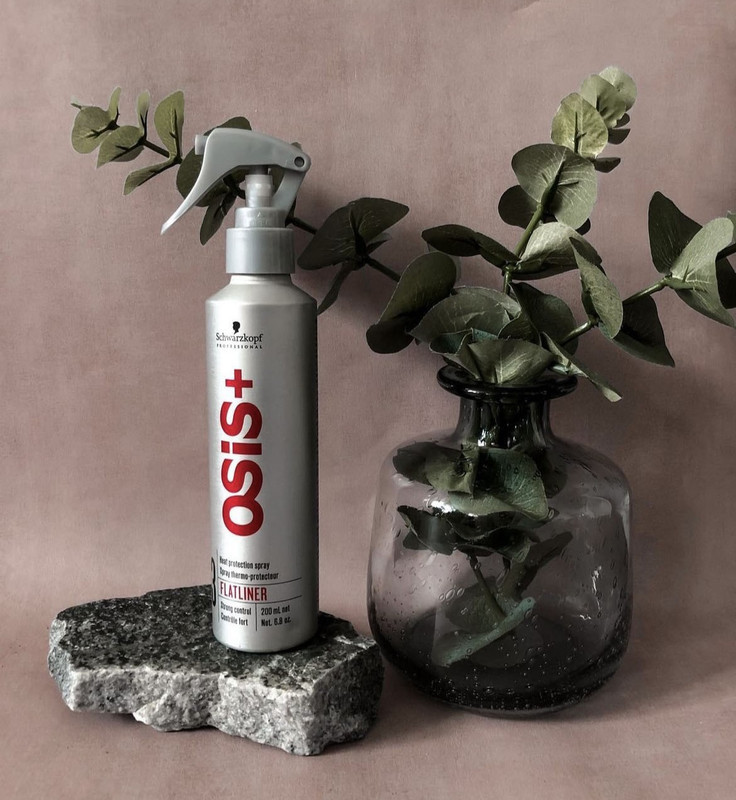 A picture of a heat protection spray with silver bottle and red text