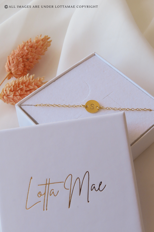 This dainty and personalizable disk bracelet is the perfect way to show off your personality. Crafted from 925 sterling silver and 18k gold plated, this bracelet is sure to turn heads wherever you go. The initial of your choice will be hand stamped onto the disk, making it a totally unique piece of jewelry that you can wear with pride. Whether you choose your own initial or a special memento of someone close to you, this bracelet is a wonderful way to express who you are. Perfect for everyday wear, it will add a touch of elegance to any outfit. Add this beautiful and personalized piece of jewelry to your collection today!
