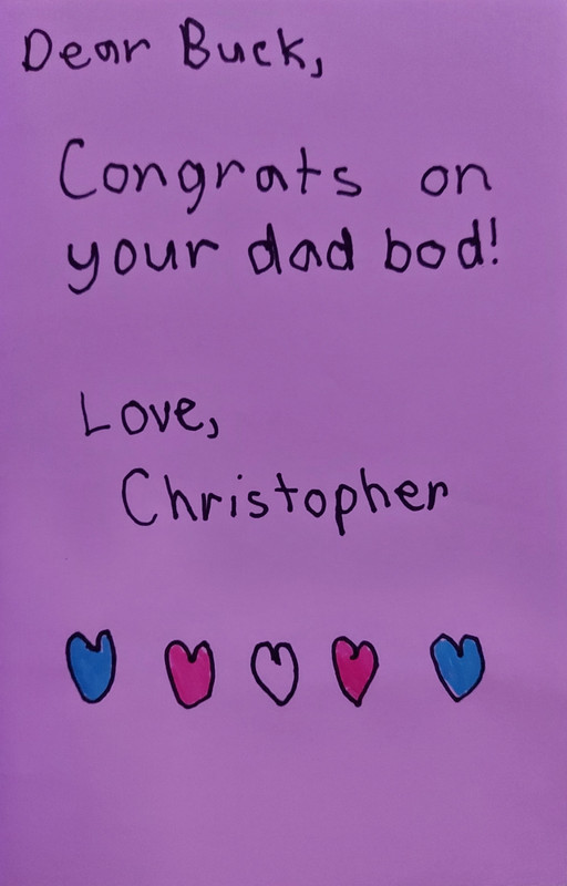 The inside of said card which reads, ‘Dear Buck, congrats on your dad bod! Love, Christopher’ with hearts in the trans flag colours underneath of it.