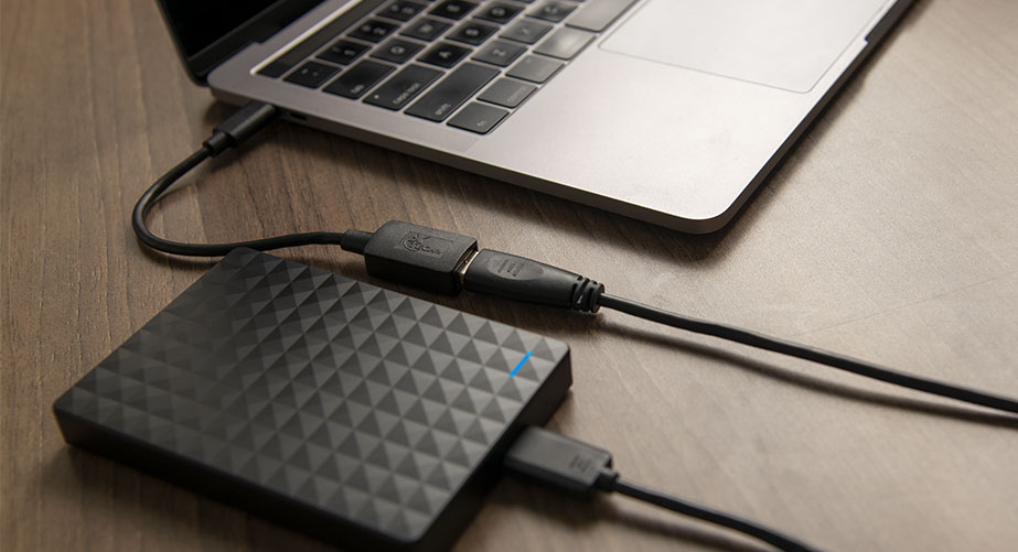 Adaptador Xtech conectado a una laptop, mostrando su uso con múltiples periféricos.