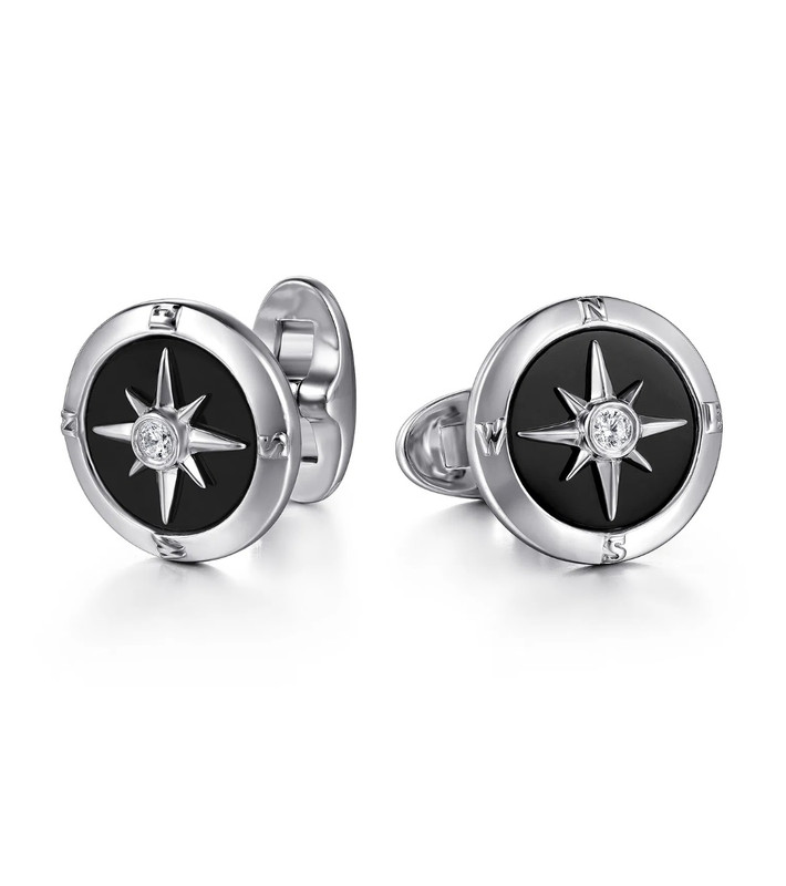 Silver cufflinks with a black circle in the center, made to look like a compass with a clear diamond in the middle.