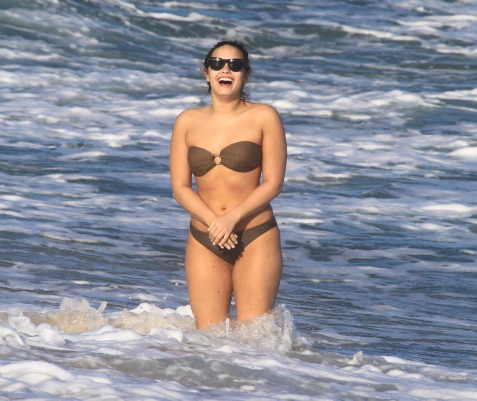 With her slim body and Brown/Black hairtype without bra (cup size 34B) on the beach in bikini
