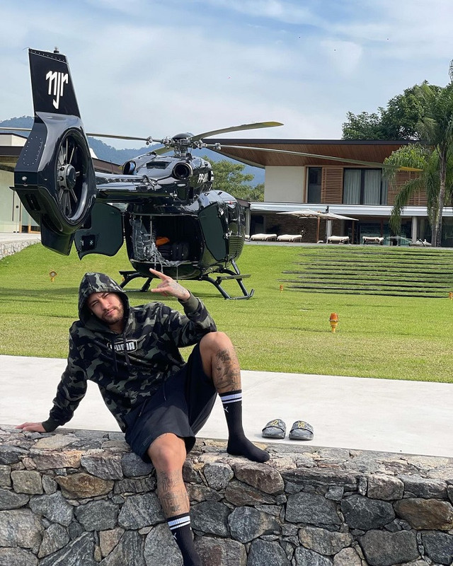 Neymar berpose dengan helikopter mewahnya yang terparkir di halaman rumah.