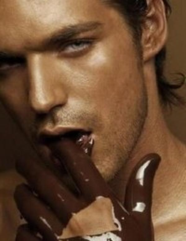 muškarac sa otopljenom čokoladom na prstima