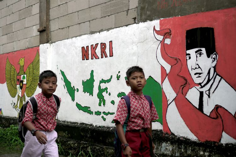 Pelajar melintas di depan mural mantan presiden Soekarno, NKRI dan Pancasila di Segara Makmur, Tarumajaya, Bekasi, Jawa Barat, Kamis (15/2/2018). Mural kepahlawanan dan nasionalisme banyak menghiasai jalan kampung untuk mengingatkan anak-anak masa perjuangan kemerdekaan.

