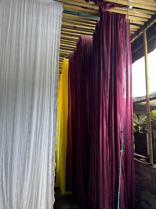 Artisan working in the manual dyeing process for the linen kimono dresses at Atelier Mizuni's ethical workshop.