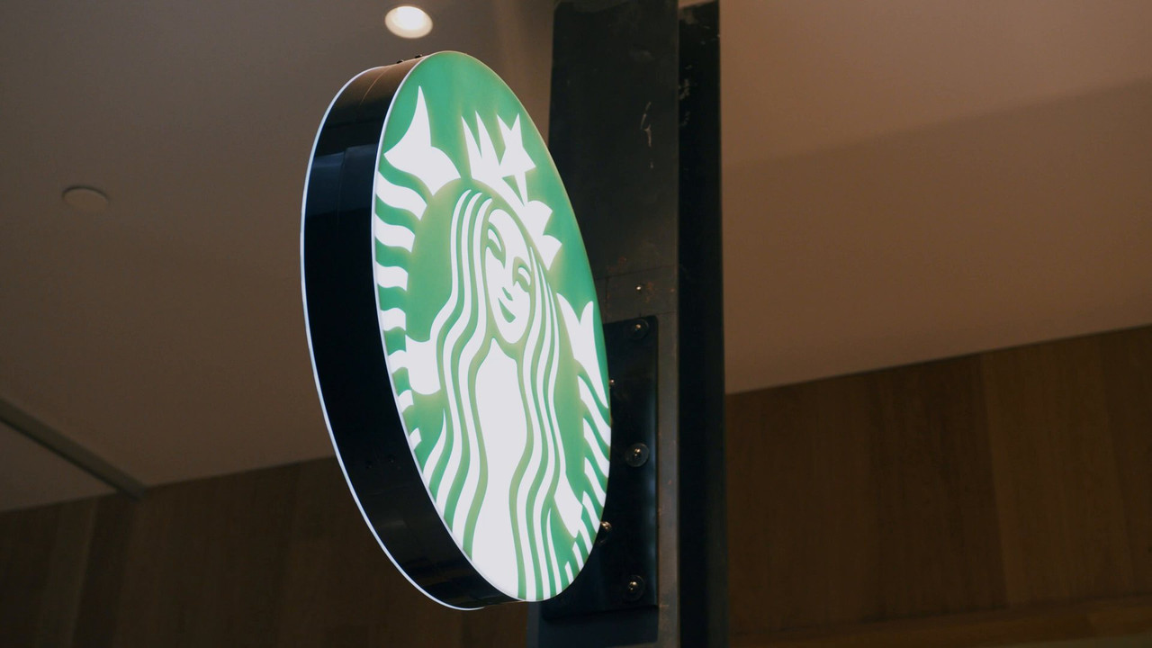 Illuminated Starbucks blade sign installed inside the finished store