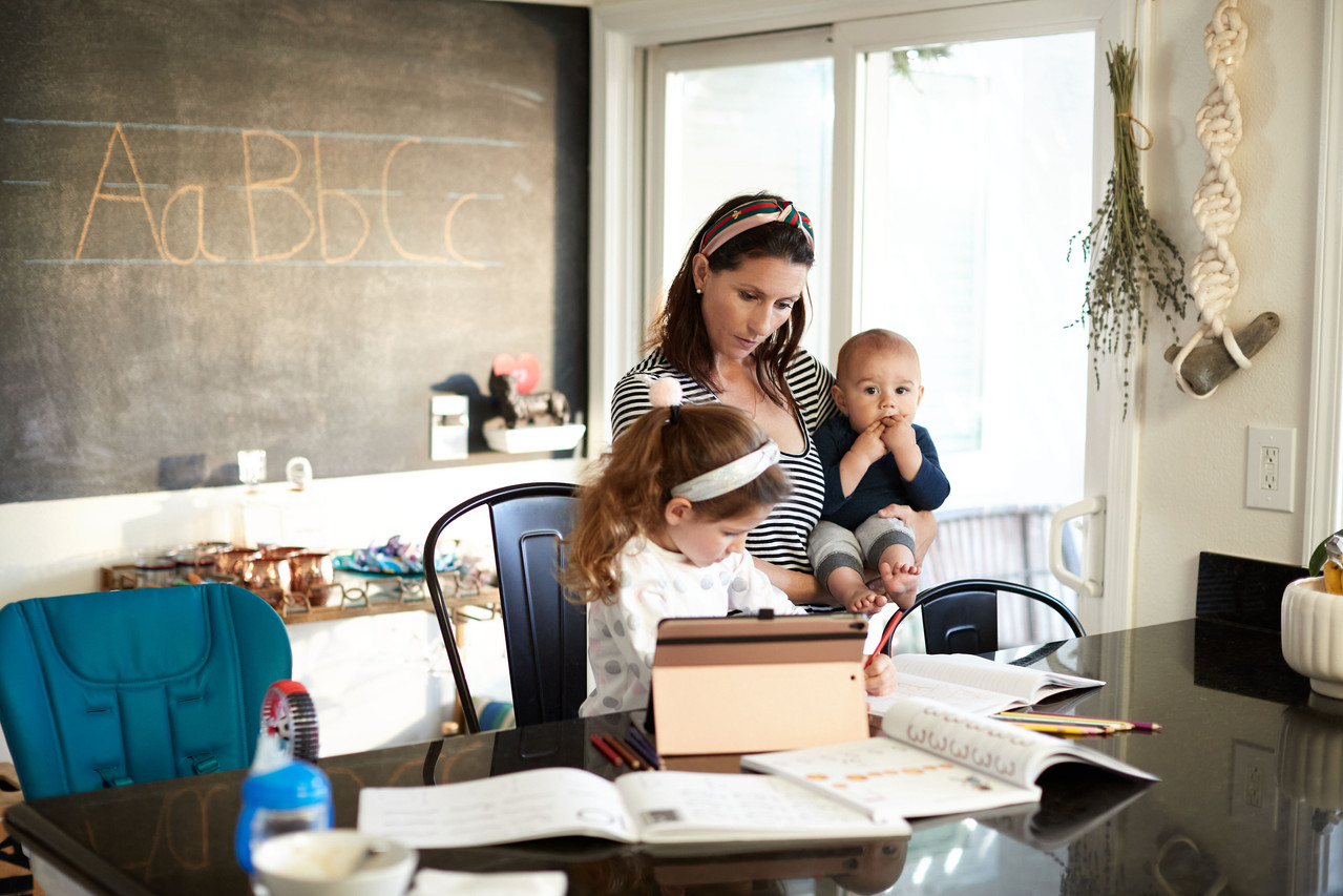 A parent and child reading and learning together at home