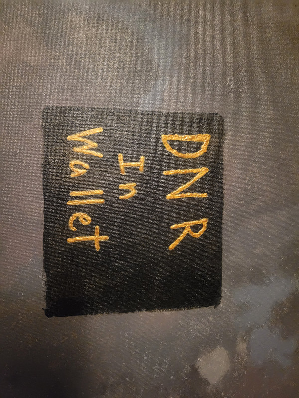 An acrylic painting of a black square on a gray background which is made of many shades of gray The black square has gold text on it that reads DNR In Wallet. The square is located just below the center of the picture.