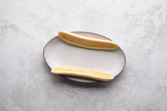prepolovljene banane na tanjiru za banana split