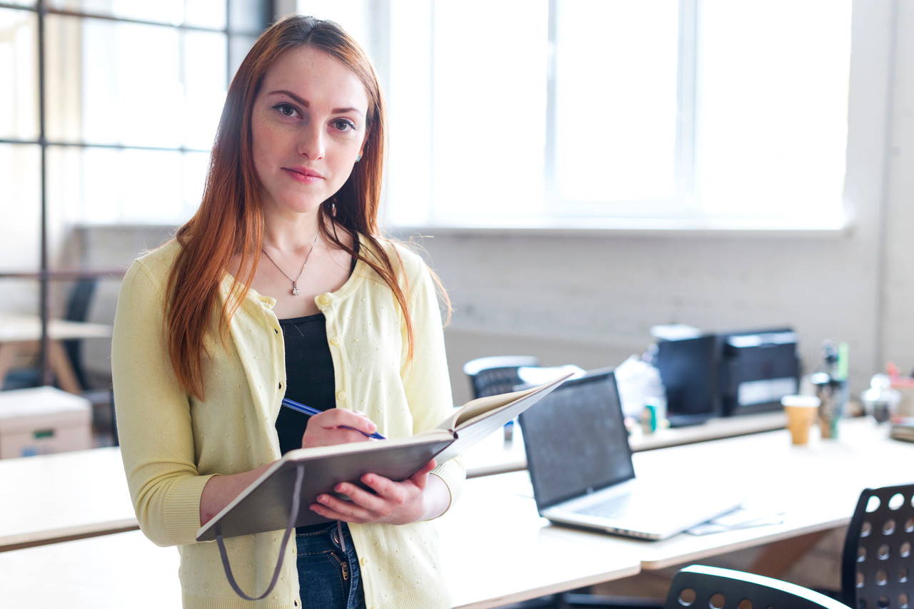front view businesswoman holding notebook pen looking camera 2