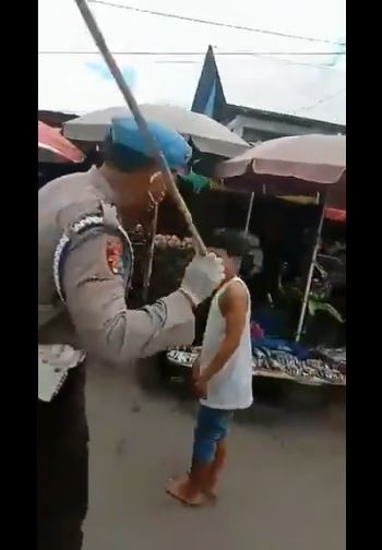 Polisi di Ambon tengah memukul warga yang kedapatan tak pakai masker