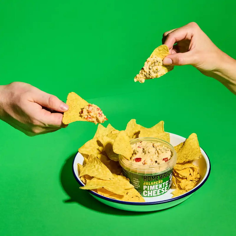 Homewrecker Jalapeño Pimento Cheese served with tortilla chips against a green background