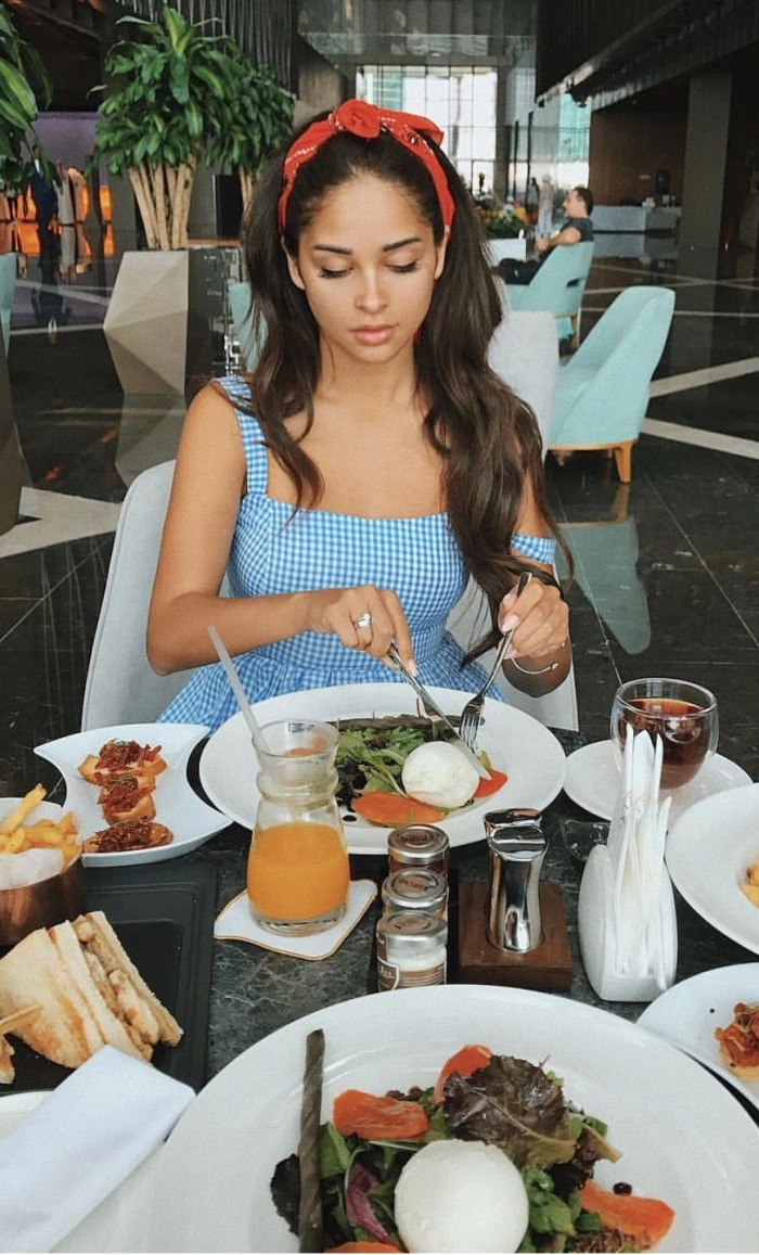 A girl with long strong black hair is having lunch