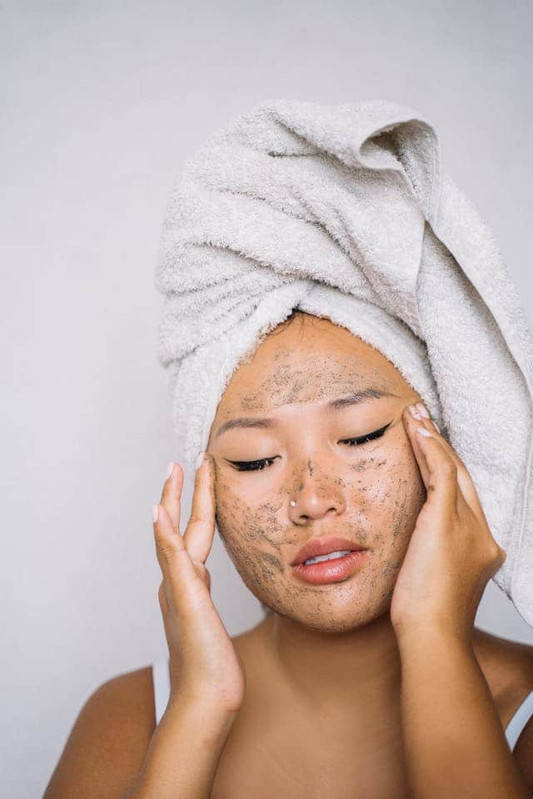 a girl exfoliating her face for glowing skin 