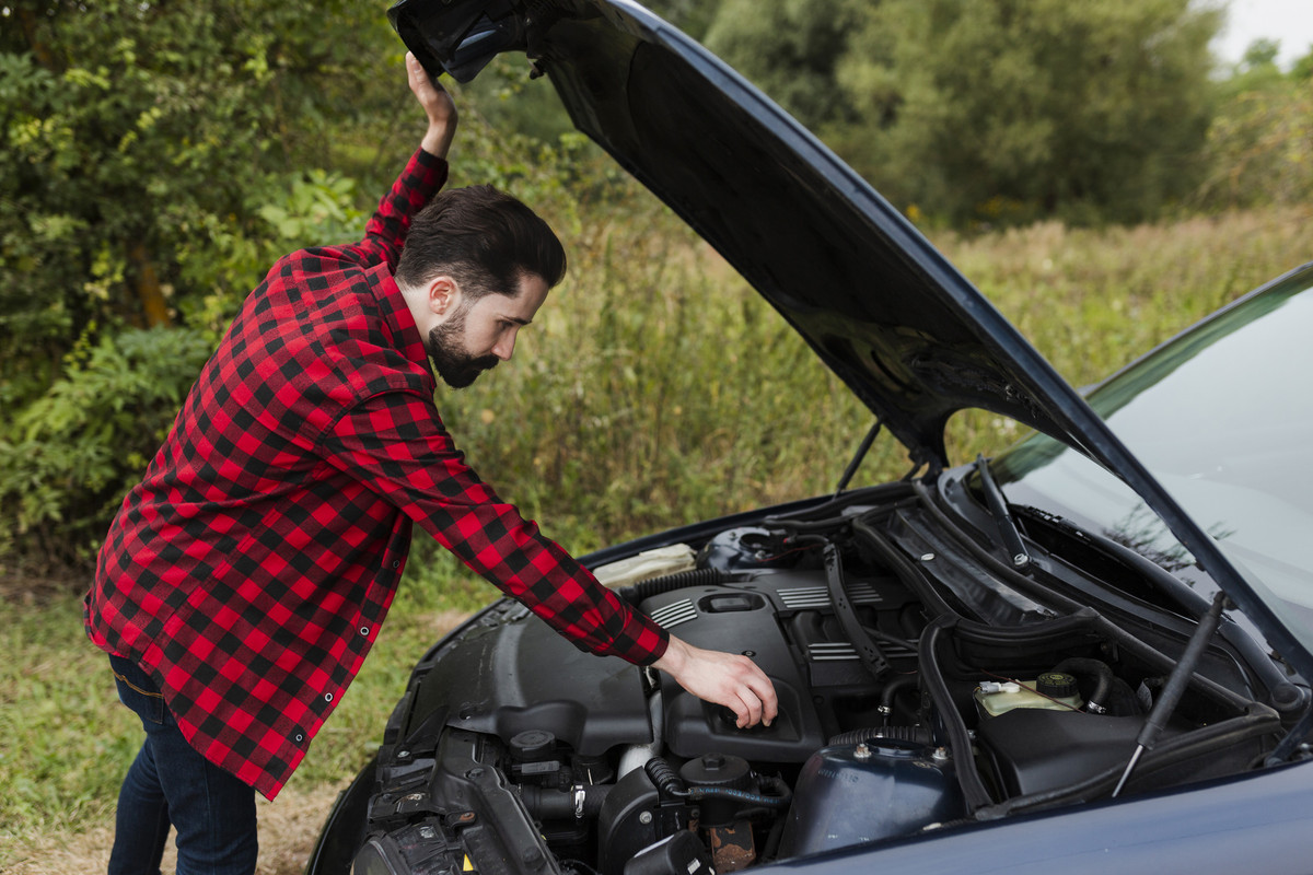 side-view-man-checking-engine-1