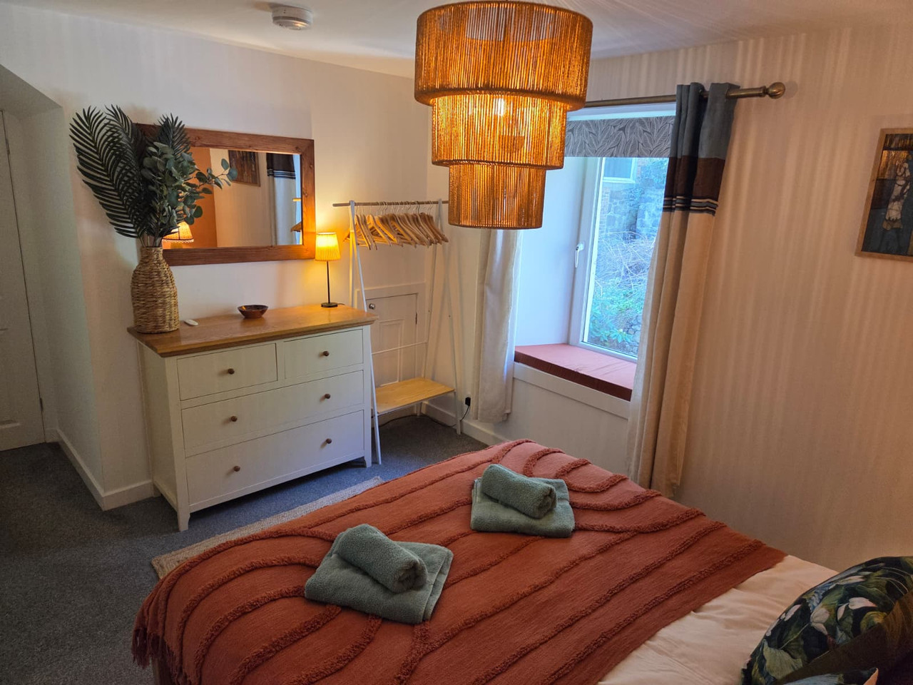 King bedroom with dresser and window seat