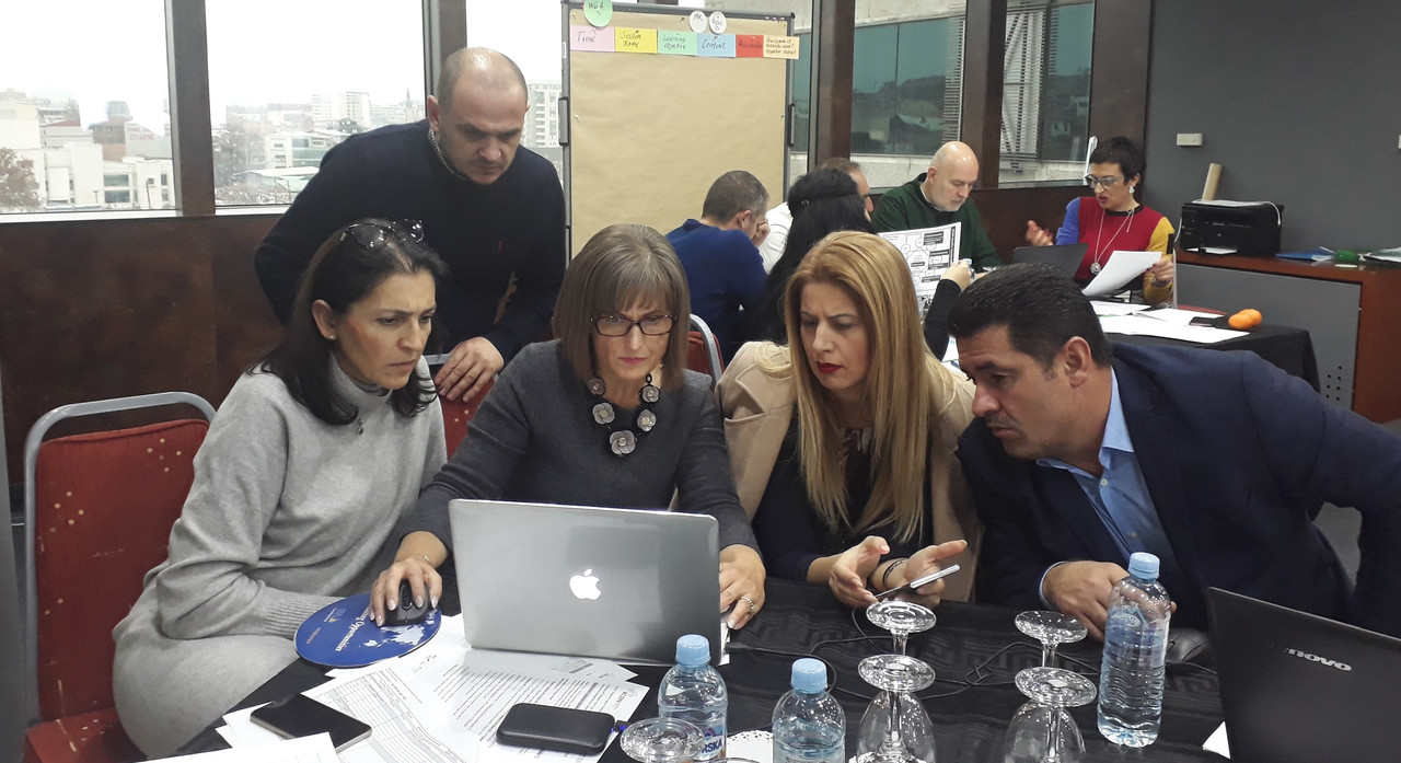 Doctor Gjinali with multiple water professionals at a table